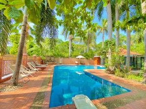 a swimming pool in a backyard with palm trees at E-outfitting Golden Country Hotel in Mandalay