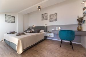 a bedroom with a bed and a blue chair at Pansion Tina in Šilo +37 photos