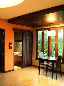 a dining room with a black table and chairs at Burapa Boutique in Chiang Mai