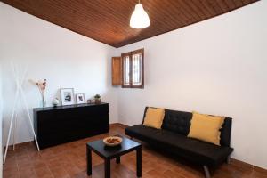un soggiorno con divano nero e tavolo di Borgo Hospitality a San Piero a Sieve