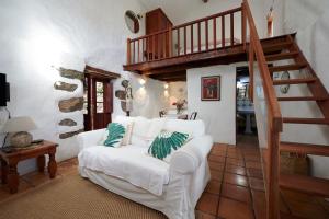 a living room with a white couch and a staircase at Casita Pedro González in Erese