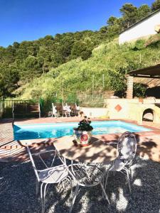 een tafel en stoelen naast een zwembad bij Casa África in Canillas de Albaida