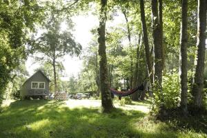 una hamaca en el bosque junto a una cabaña en Camping Ile de Boulancourt en Boulancourt