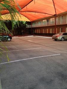 a parking lot with cars parked in front of a building at Francis Phillip Motor Inn and The Lodge in Singleton