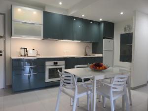 - une cuisine avec une table blanche et des chaises blanches dans l'établissement Apartamentos Mar D'Or, à L'Estartit