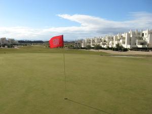 a red sign sitting on top of a green field at First Floor Non Smoking Air Conditioned 4 Person Luxury Golf Apartment in Corvera