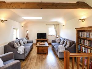 a living room with two couches and a tv at Chestnuts Barn in Belper