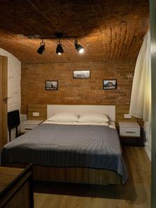 sypialnia z łóżkiem z drewnianą ścianą w obiekcie Villa SOFI w Lwowie