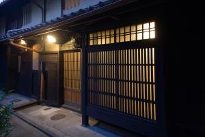an entrance to a building with a gate at night at Demizu Machiya Machiya Inn in Kyoto