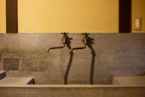 a pair of faucets on a concrete wall at Demizu Machiya Machiya Inn in Kyoto