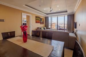 a living room with a couch and a table with a vase of flowers at The Sails G6-07 on Timeball Boulevard in Durban