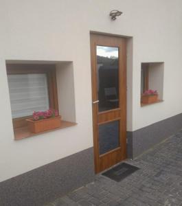 a door on the side of a building with two windows at U Beaty, niezależne mieszkania do wynajęcia in Ochotnica Górna
