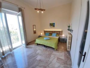 um quarto com uma mesa verde num quarto com janelas em Confortevole e luminoso appartamento zona Gallipoli em Galatone