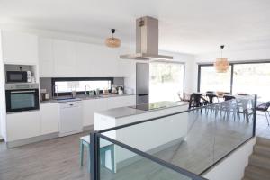 a kitchen with white cabinets and a dining room at Cairnvillas Villa Essencia C45 - Luxury Villa with Private Pool near Beach in Aljezur