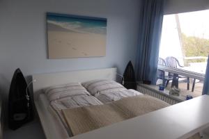 Schlafzimmer mit einem Bett und einem Fenster mit einem Tisch in der Unterkunft Ostsee-Apartment "Weite Welt" in Kiel
