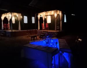 ein dunkles Zimmer mit einem Tisch und roten Stühlen in der Unterkunft Jungle retreat dandeli - Homestay in Joida