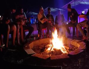 a group of people sitting around a fire at Jungle retreat dandeli - Homestay in Joida