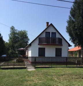 a white house with a black fence at Gólyafészek in Abádszalók