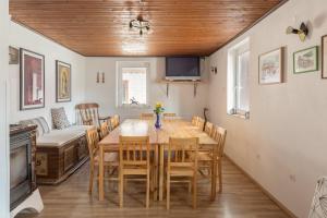 uma sala de jantar com mesa e cadeiras e uma televisão em Hostel Mama Minka em Bohinj