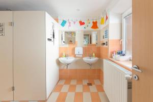 a bathroom with two sinks and two mirrors at Hostel Mama Minka in Bohinj