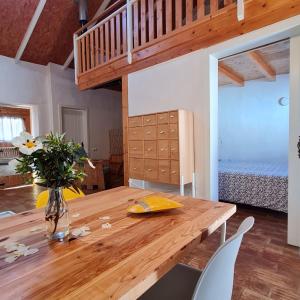 a dining room with a wooden table and a bed at Casa Blanca in Odeceixe