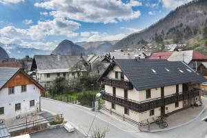 a village with buildings and mountains in the background at Hostel Mama Minka in Bohinj
