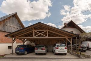 two cars parked in a parking lot in front of a building at Hostel Mama Minka in Bohinj