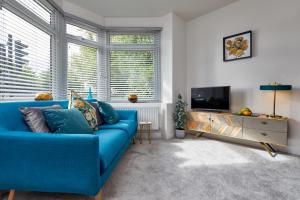 a living room with a blue couch and a tv at Coppergate Mews Apartment 2 in Doncaster