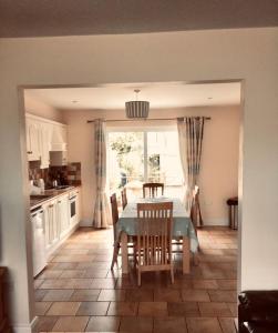 een keuken met een tafel en stoelen en een eetkamer bij Fuchsia House in Valentia Island