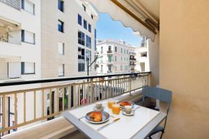 una mesa con un plato de comida en el balcón en Antares S YourHostHelper, en Cannes
