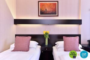 En eller flere senger på et rom på Prezident Hotel