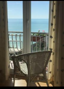 a wicker chair on a porch looking out at the ocean at Camera Vista Mare Sunrise-Top Panorama in Sirolo in Sirolo