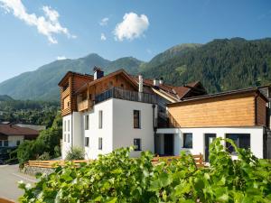 a white building with mountains in the background at Schneggnheisl - Appartement in Sautens