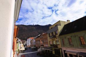 una calle de la ciudad con edificios y una montaña en el fondo en Viva la Vida Hostel en Braşov