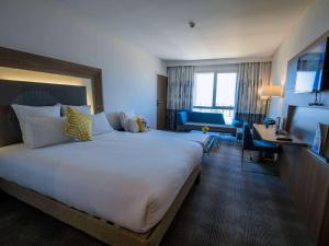 モハメディアにあるNovotel Mohammediaの大きなベッドとデスクが備わるホテルルームです。