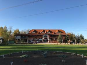 a large building with a red roof at Muskátli Panzió és Étterem in Újhartyán