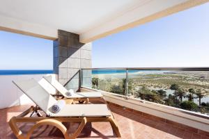 a balcony with chairs and a view of the beach at Meliá Fuerteventura in Costa Calma