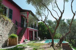 a pink house with a pool in front of it at Cà del Mago Pool garden & spa, only adults in Lerici