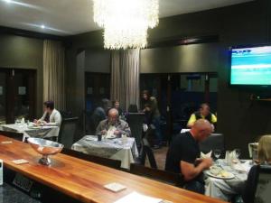 a group of people sitting at tables in a restaurant at Kusile Guest House in Burgersfort