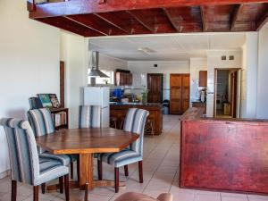 uma cozinha e sala de jantar com uma mesa de madeira e cadeiras em Black Rock Lodge em Port Edward