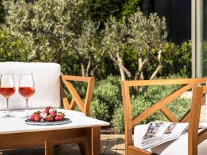 a table with two glasses of wine and a plate of fruit at Swissôtel Resort Bodrum Beach in Turgutreis