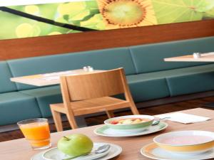 
a table with a plate of food and a glass of orange juice at ibis Ulm City in Ulm
