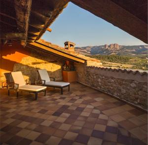 a patio with chairs and a view of the mountains at Casa Rumbet in Horta de San Joan