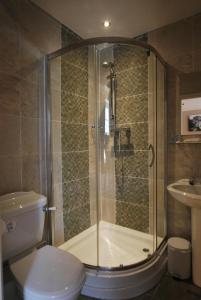 uma casa de banho com um chuveiro, um WC e um lavatório. em the punchbowl hotel em Kendal