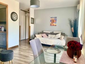 a living room with a couch and a glass table at APPARTEMENT LES COLLINES in Calvi