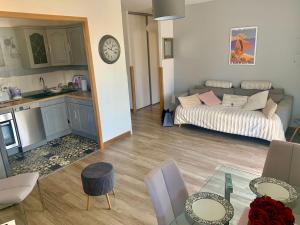 een woonkamer en een keuken met een bank en een tafel bij APPARTEMENT LES COLLINES in Calvi