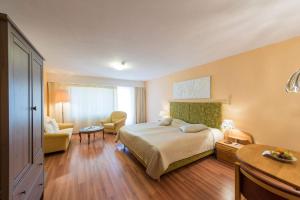 una stanza d'albergo con un letto e una sedia di Badehotel Salina Maris – Wellness & Vintage a Mörel