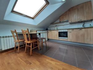 a kitchen with wooden cabinets and a skylight at Ático La Plaza in Arriondas +13 photos