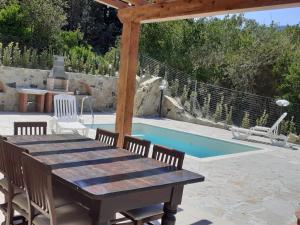a wooden table and chairs next to a swimming pool at VILLETTA SANTA LUCIA in Marina di Campo