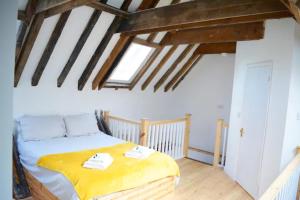 een slaapkamer met een bed met een gele deken bij Loaf 2 at The Old Granary Converted Town Centre Barn in Beverley